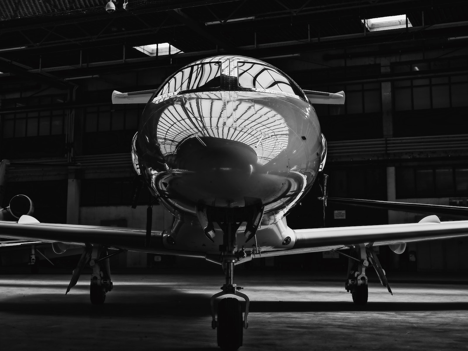 grayscale photo of man standing near airplane