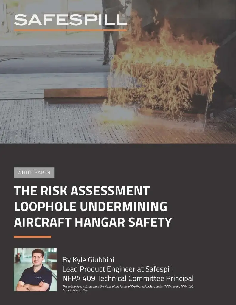 Fire simulation test underway on metal floor, highlighting safety in aircraft hangars.